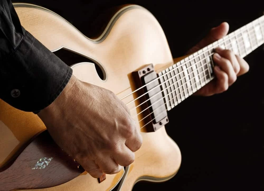 Closeup of man playing an acoustic guitar.