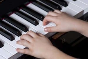 Children's hands playing a piano